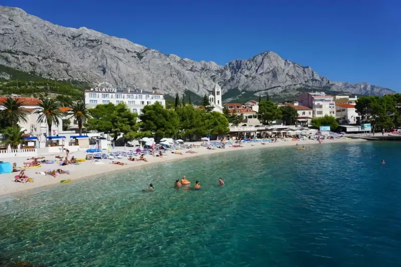 Słoneczna plaża w Baška Voda, z turkusową wodą i górami w tle. To idealne miejsce na relaks i odkrywanie atrakcji.